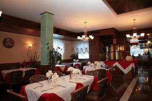 a dining room with tables with red and white tablecloths at Hotel Marianna in Rocca Pietore