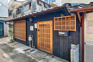 a blue building with orange doors on a street at Connect inn Kyoto-Gojo in Kyoto +4 photos