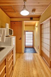 a kitchen with a microwave and a hallway at Connect inn Kyoto-Gojo in Kyoto