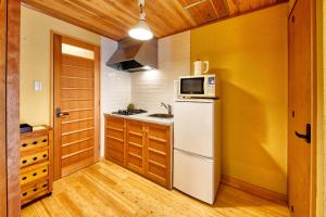 a kitchen with a white refrigerator and a microwave at Connect inn Kyoto-Gojo in Kyoto
