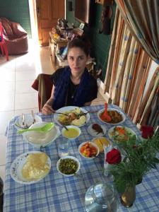 una mujer sentada en una mesa con platos de comida en CL Dreams Homestay, en Kochi
