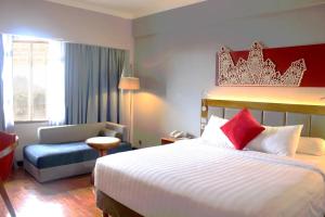 Postel nebo postele na pokoji v ubytování Monopoli Hotel Bukittinggi