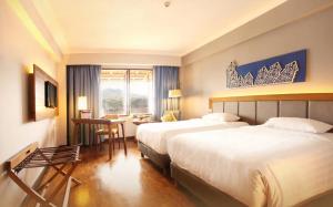 Postel nebo postele na pokoji v ubytování Monopoli Hotel Bukittinggi