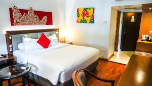 Postel nebo postele na pokoji v ubytování Monopoli Hotel Bukittinggi