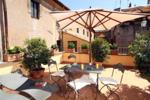 un tavolo e sedie sotto un ombrellone su un patio di Vivaldi Luxury Rooms a Roma
