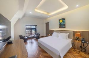 una camera da letto con un grande letto bianco e una scrivania di TP Dalat Hotel a Da Lat