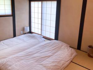 Postel nebo postele na pokoji v ubytování Kabuto Villas ー古民家ステイー + 10 fotografií