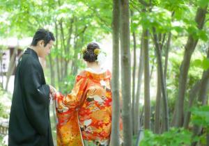 a man and woman in a kimono walking through a forest at Residential Hotel GRAN梅香 Newly opened Hotel Baika Family friendly Free parking 10 minutes to USJ in Osaka