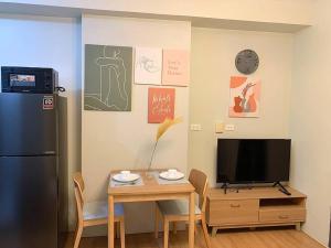 a kitchen with a small table and a refrigerator at Affordable Condo, near IT Park in Cebu City