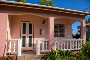 a small pink house with a white door at Good Times in Gingerland
