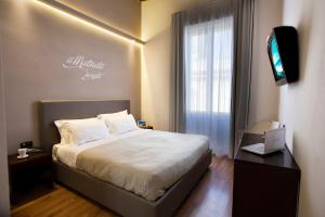 
a hotel room with a bed and a television at BADIA NUOVA Apart Hotel , Restaurant , Rooftop Lounge Bar in Trapani
