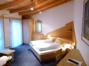 Cette chambre comprend un lit, une table et un bureau. dans l'établissement Hotel Stocker, à St. Valentin auf der Haide