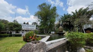 a garden with a fountain in front of a building at De Karanganjar Inn in Berni