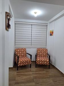 two chairs sitting in a room with a window at Dormitorio matrimonial 01 in Lima