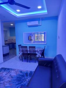 un salon avec un canapé et une table avec des chaises dans l'établissement Jerai Geopark Cottage Song Song, à Kampong Permatang Serentang