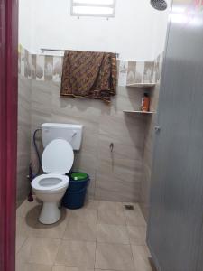 une salle de bain avec des toilettes blanches dans une chambre dans l'établissement Jerai Geopark Cottage Song Song, à Kampong Permatang Serentang