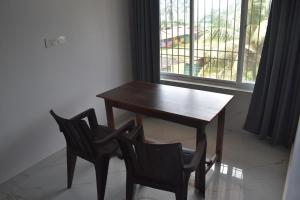 a wooden table and two chairs next to a window at GUNDAPPA cafe GOKARNA KUDLE beach in Gokarn +27 photos