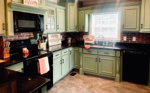 a kitchen with green cabinets and a sink at Private Cottage on Lookout Mountain Near Ruby Falls & Rock City in Lookout Mountain