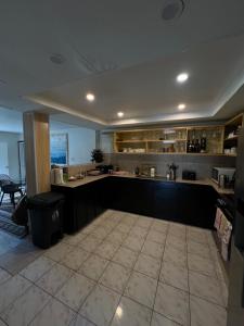 a large kitchen with black cabinets and a tile floor at 'Ataongo Residence - Boutique Island Stay, Central Nuku'alofa in Nuku‘alofa