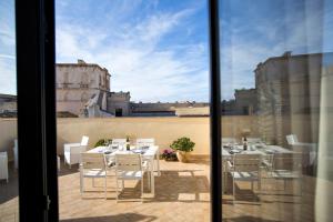 vista su un patio con tavoli e sedie bianchi di BADIA NUOVA Apart Hotel a Trapani
