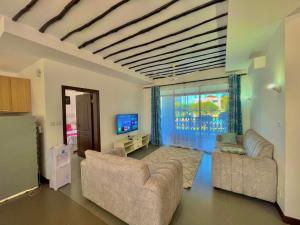 a living room with two couches and a tv at Bahari Haven TWO Bedroom Kikambala in Kilifi