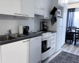 a white kitchen with a sink and a stove at Cozy 1BR City Centre Home with Free Parking in Kuopio