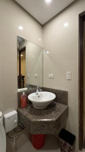 a bathroom with a sink and a mirror at New Cozy Condo in Eastwood in Manila