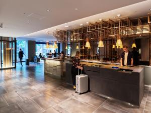 京都sequence KYOTO GOJO的酒店大堂里，一位女士提着行李箱 更多52张照片