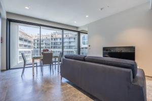 a living room with a couch and a table with chairs at Piazza Panorama In The Island's Tallest Landmark in St Julian's