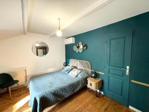 ein Schlafzimmer mit einem Bett und einer blauen Wand in der Unterkunft Villa LEONA CLIM PARK in Bollène