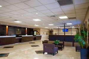 a lobby with a waiting room with desks and chairs at Clarion Inn & Suites Miami International Airport in Miami