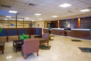 a lobby with a waiting room with chairs and a desk at Clarion Inn & Suites Miami International Airport in Miami