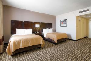 a hotel room with two beds in a room at Clarion Inn & Suites Miami International Airport in Miami