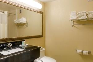 a bathroom with a toilet and a sink and a mirror at Clarion Inn & Suites Miami International Airport in Miami