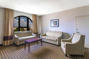 a living room with two chairs and a couch and a table at Clarion Inn & Suites Miami International Airport in Miami