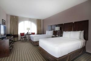 a hotel room with two beds and a television at Clarion Inn & Suites Miami International Airport in Miami