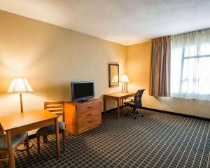 a hotel room with a desk and a television at Clarion Inn & Suites Miami International Airport in Miami