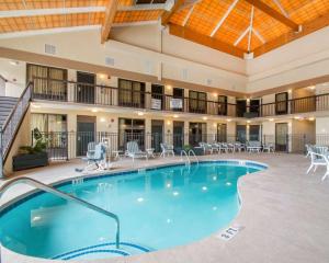 a large pool in a hotel with tables and chairs at Quality Inn & Suites Ridgeland in Ridgeland