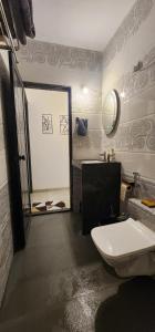 a bathroom with a toilet and a sink and a mirror at Boho 44 in Goa