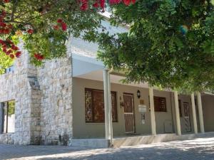 a building with a tree with red flowers in front of it at Avemore Island Apartment Sedgefield in Sedgefield +8 photos