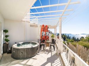 a hot tub on a balcony with a table and chairs at Apartments Bla evi - Comfort Two Bedroom Apt with Hot Tub and Sea View in Mlini