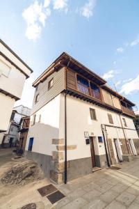 a small white building with a wooden roof at CR "El Arrabal" Valle de La Vera in Villanueva de la Vera