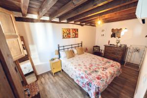 a bedroom with a bed and a wooden floor at CR "El Arrabal" Valle de La Vera in Villanueva de la Vera