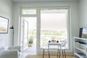 a living room with a table and a sliding glass door at Framnäs Suites in Kirkkonummi