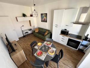 トリノにあるMinù House - Confortevole vicino al Centroのテーブルと椅子のあるキッチンとリビングルーム