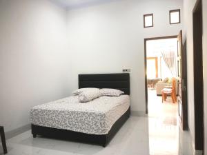 a bedroom with a bed with a black headboard at Pondok Anugerah in Rantepao