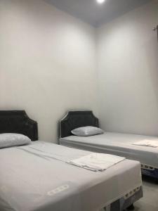 two twin beds in a room withthritisthritisthritisthritisthritisthritisthritisbestosbestos at Pondok Anugerah in Rantepao