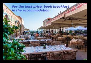 an outdoor restaurant with tables and chairs and a sign that reads for the best price at Priska Heritage Rooms in Split