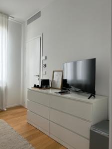 a living room with a large television on a dresser at Da Lydia in Treviso