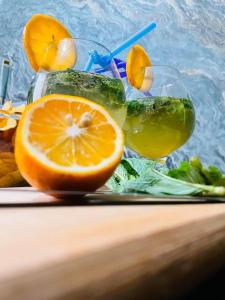 a plate with a drink and an orange slice at Guest House pesvebi in Mestia